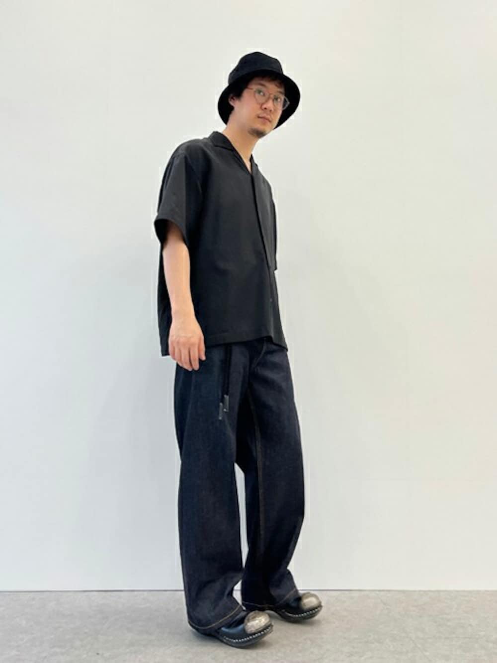 ブラック系のシャツ/ブラウス、ブルー系のデニムパンツを着用したメンズの春コーディネートの1枚目の写真