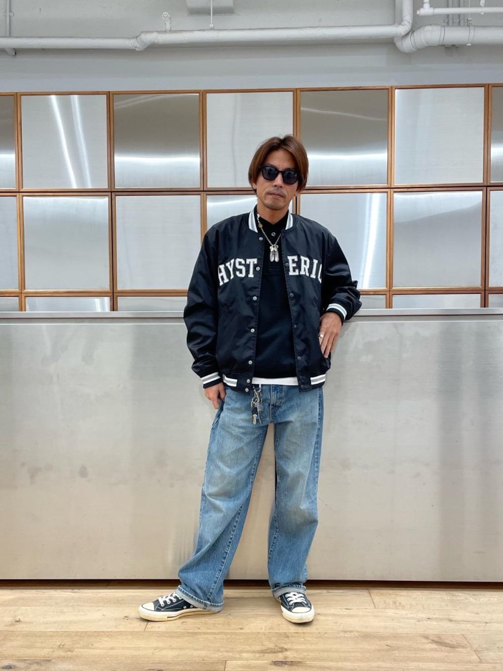 ホワイト系のTシャツ/カットソー、ブラック系のスニーカー、ブルー系のデニムパンツを着用したメンズの秋コーディネートの1枚目の写真