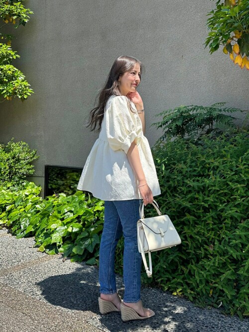 ブルー系のデニムパンツ、ホワイト系のTシャツ/カットソーを着用したレディースの春コーディネートの1枚目の写真