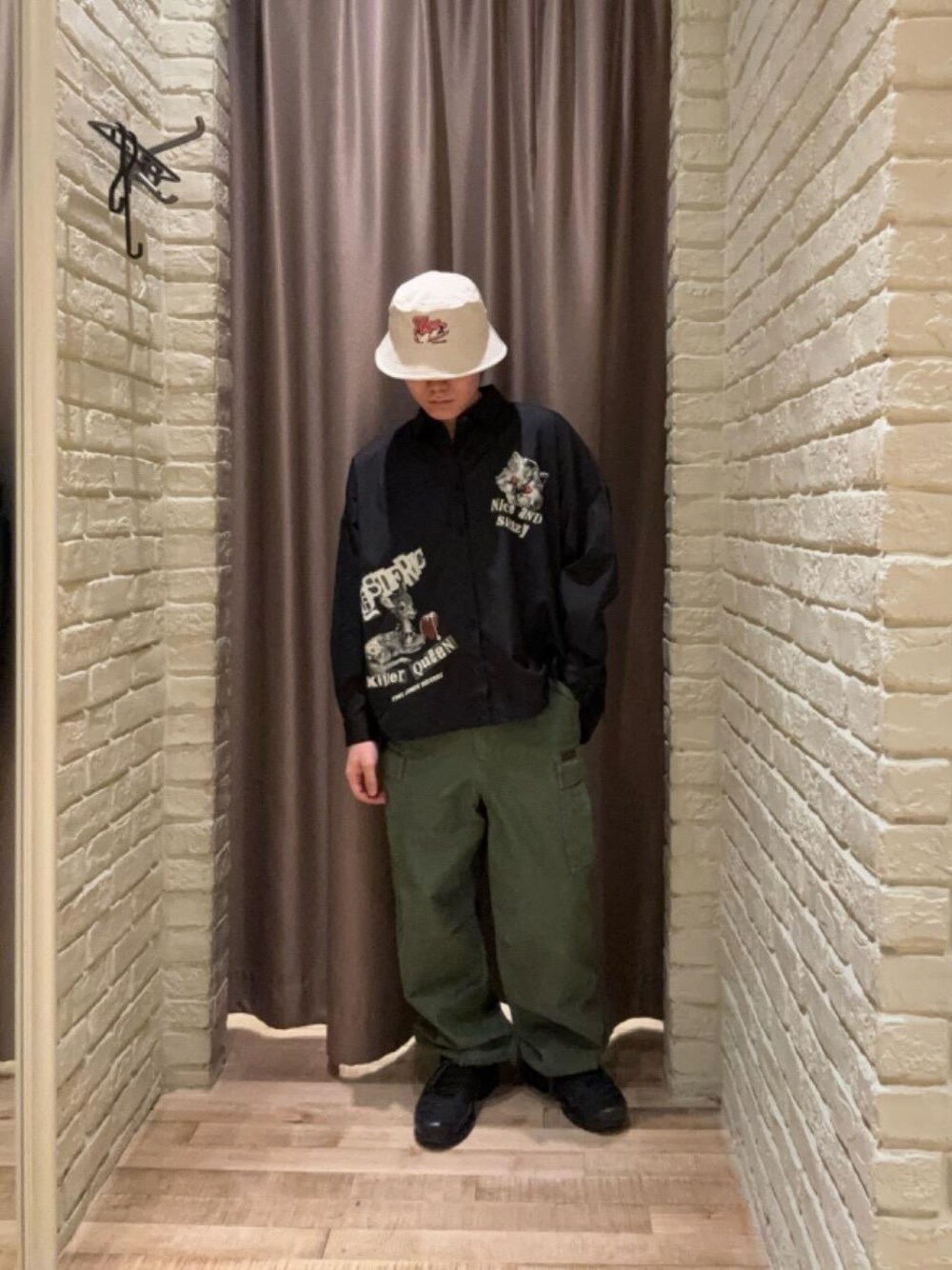 グリーン系のカーゴパンツ、ブラック系のシャツ/ブラウス、ベージュ系のハットを着用したメンズの夏コーディネートの1枚目の写真