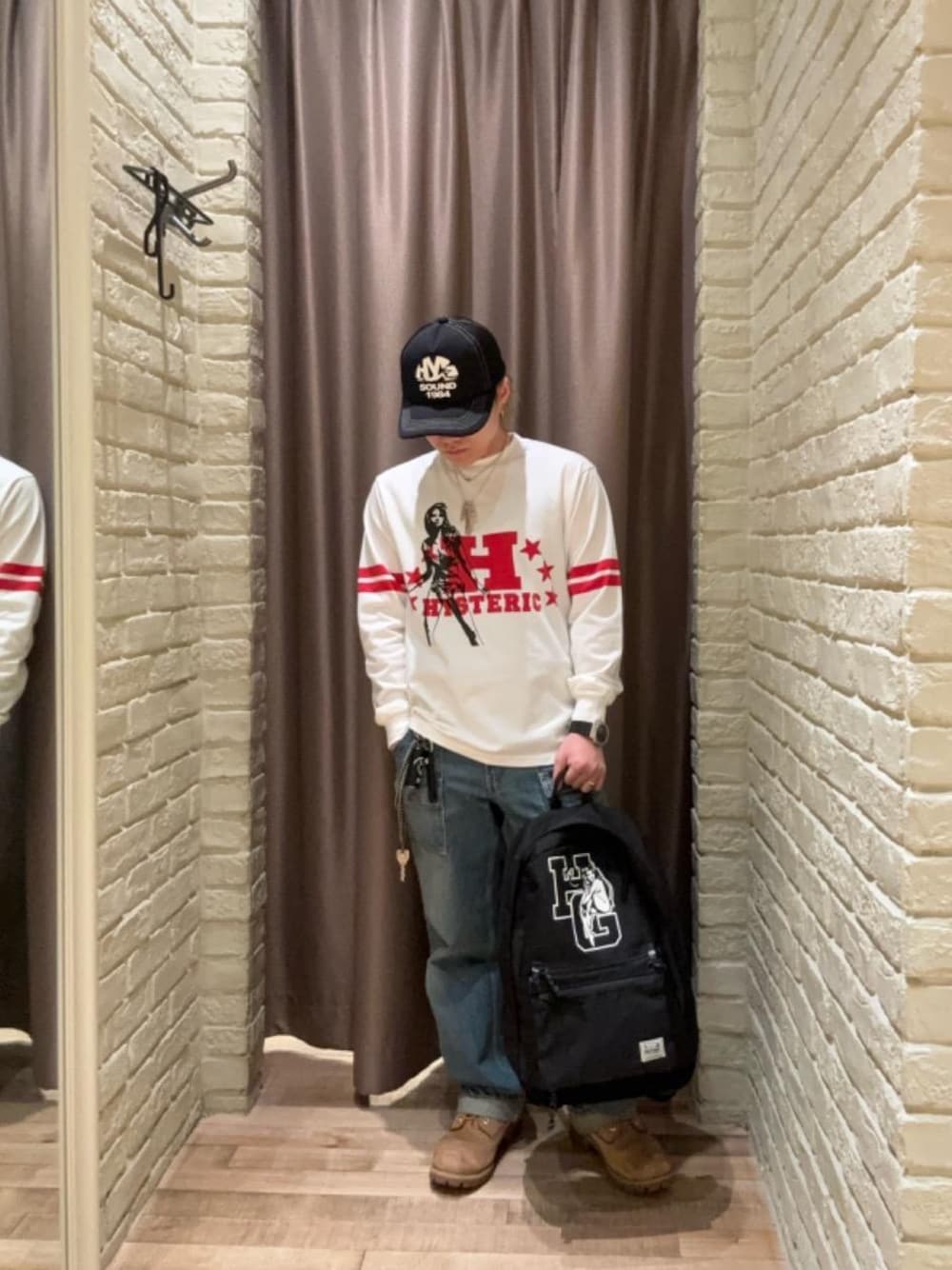 ブルー系のデニムパンツ、ブラック系のバックパック/リュック、ホワイト系のTシャツ/カットソーを着用したメンズの秋コーディネートの1枚目の写真