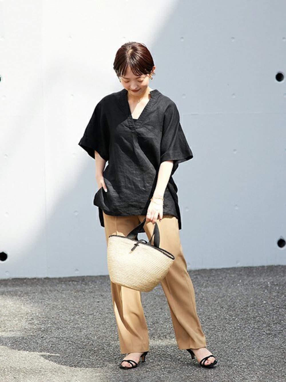 ブラック系のシャツ/ブラウス、ベージュ系のハンドバッグを着用したレディースの春コーディネートの1枚目の写真