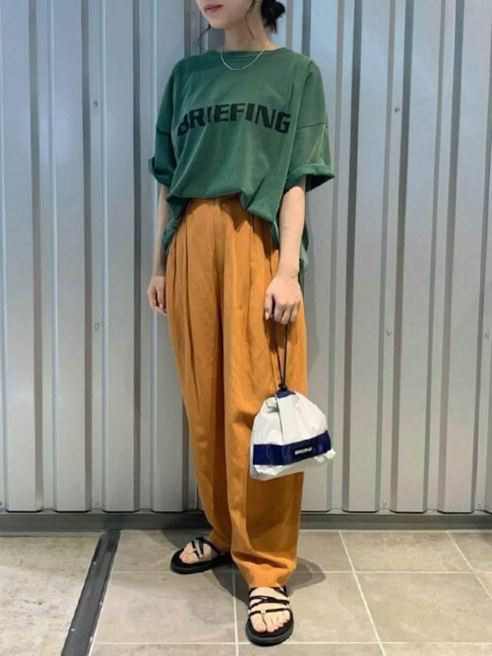グリーン系のTシャツ/カットソー、グレー系のポーチを着用したレディースの夏コーディネートの1枚目の写真