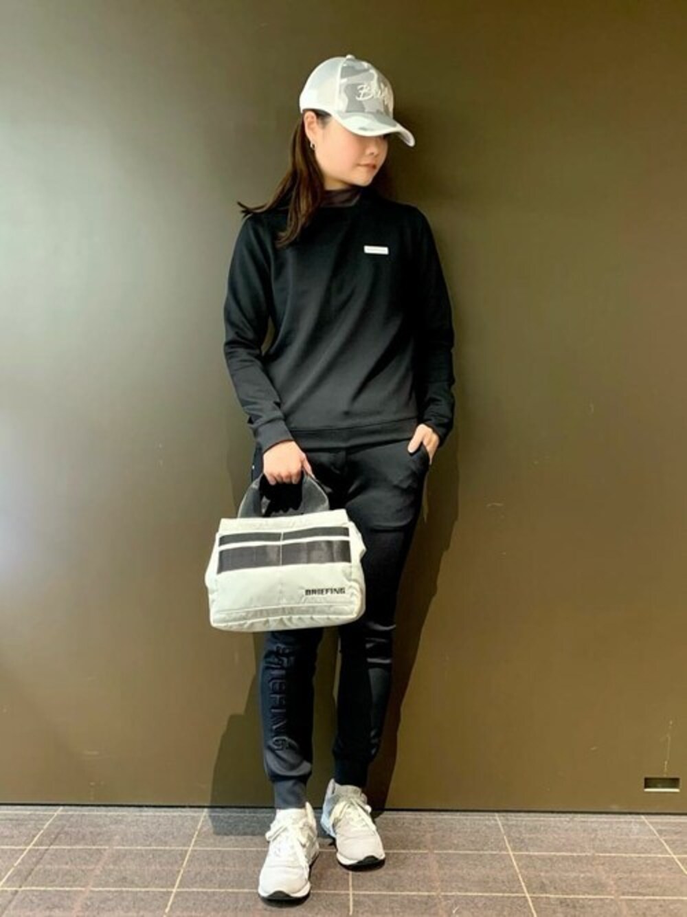 ブラック系のTシャツ/カットソー、ブラック系のその他パンツ、ホワイト系のキャップを着用したレディースの冬コーディネートの1枚目の写真