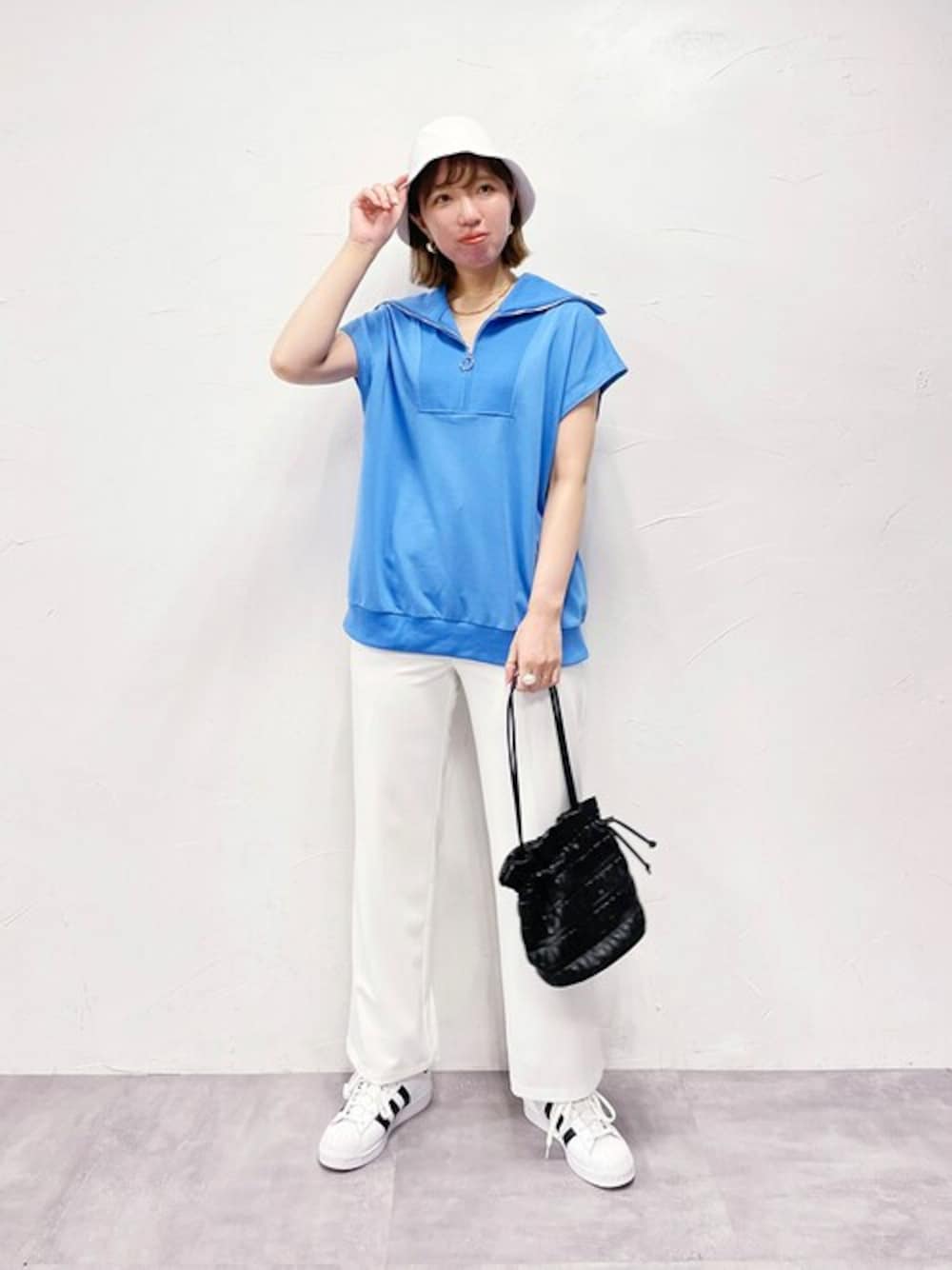 ブルー系のTシャツ/カットソー、ホワイト系のスラックスを着用したレディースの夏コーディネートの1枚目の写真