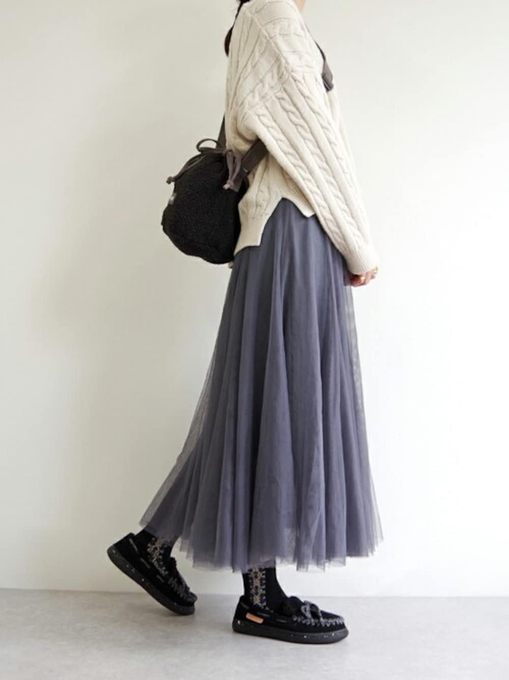 ブラック系のスリッポン、グレー系のショルダーバッグを着用したレディースの秋コーディネートの1枚目の写真