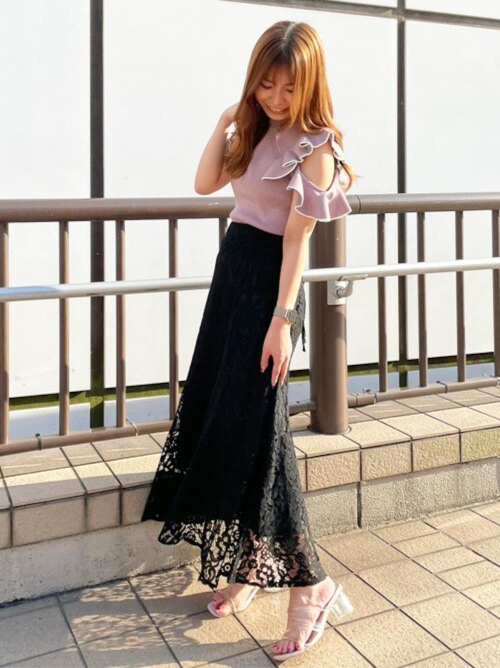 ピンク系のニット/セーター、ブラック系のスカートを着用したレディースの夏コーディネートの1枚目の写真