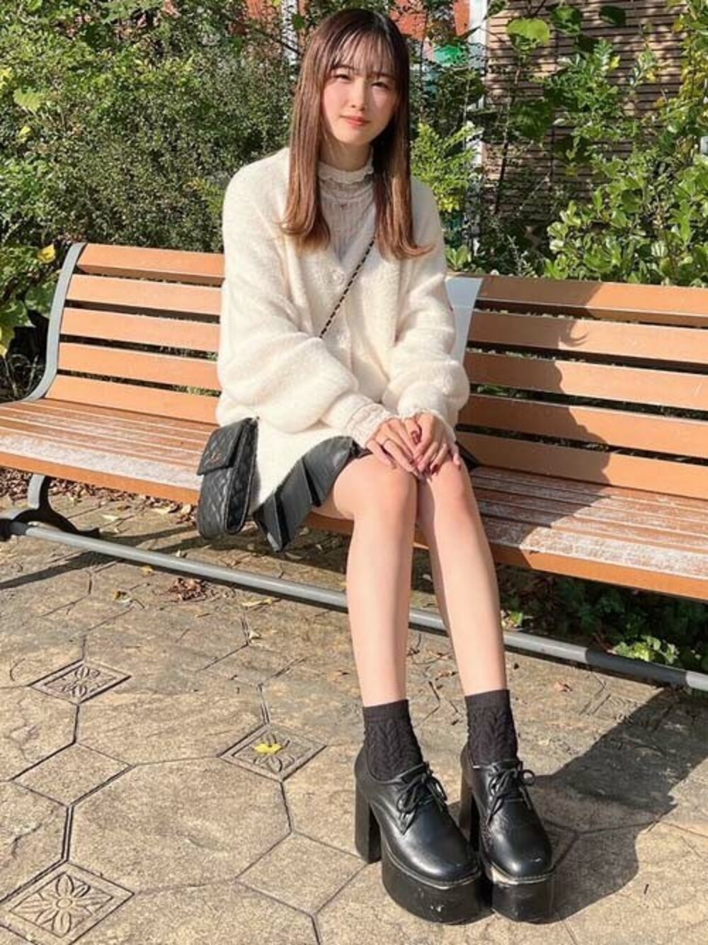 ホワイト系のその他トップス、ブラック系のスカート、ホワイト系のカーディガン/ボレロを着用したレディースの冬コーディネートの1枚目の写真