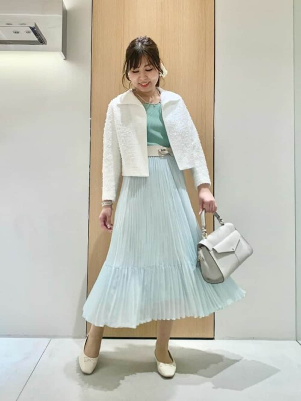 ホワイト系のノーカラージャケット、グリーン系のスカート、グリーン系のニット/セーターを着用したレディースの冬コーディネートの1枚目の写真