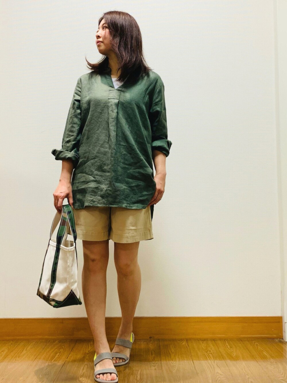 グリーン系のシャツ/ブラウス、ベージュ系のパンツ、グリーン系のトートバッグを着用したレディースの夏コーディネートの1枚目の写真