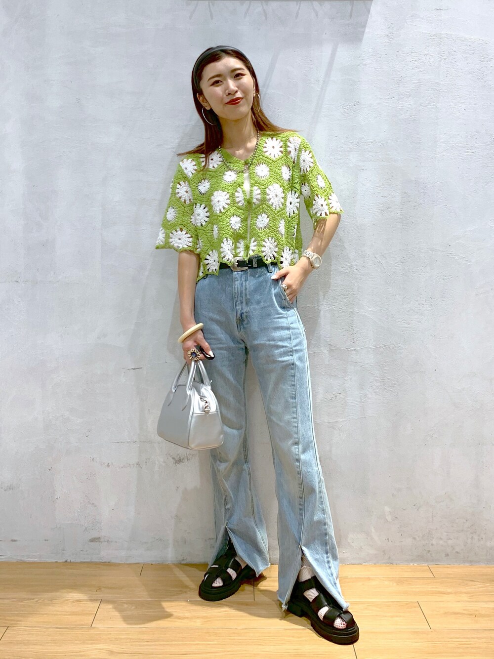 グリーン系のカーディガン/ボレロ、ブルー系のデニムパンツ、シルバー系のショルダーバッグを着用したレディースの夏コーディネートの1枚目の写真