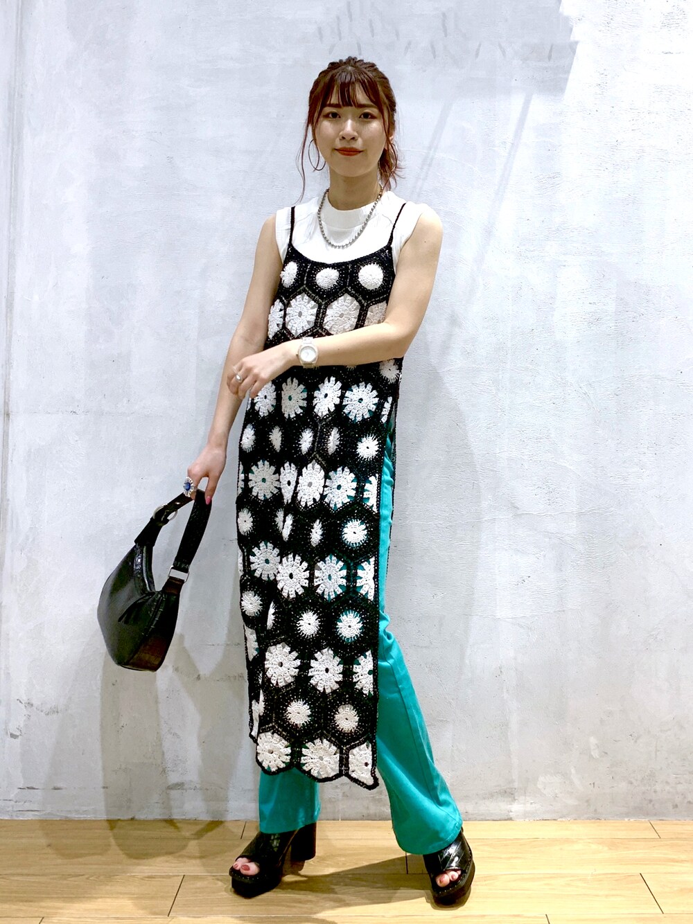 ブラック系のワンピース、ブラック系のショルダーバッグ、グリーン系のデニムパンツを着用したレディースの春コーディネートの1枚目の写真