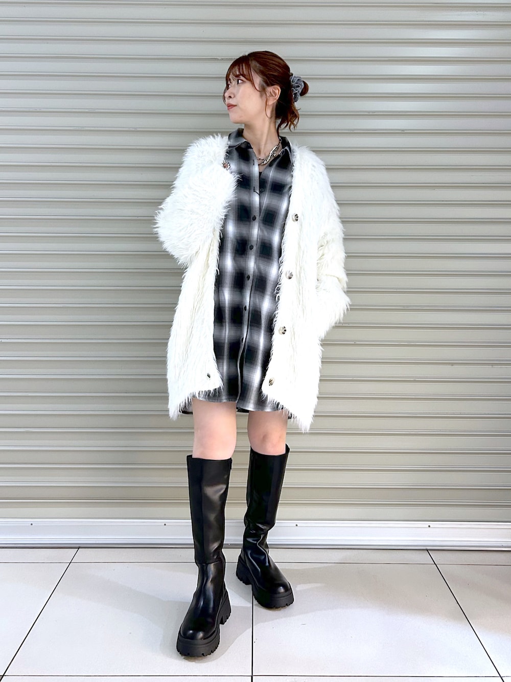 ブラック系のシャツ/ブラウス、ホワイト系のカーディガン/ボレロ、ブラック系のブーツを着用したレディースの秋コーディネートの1枚目の写真