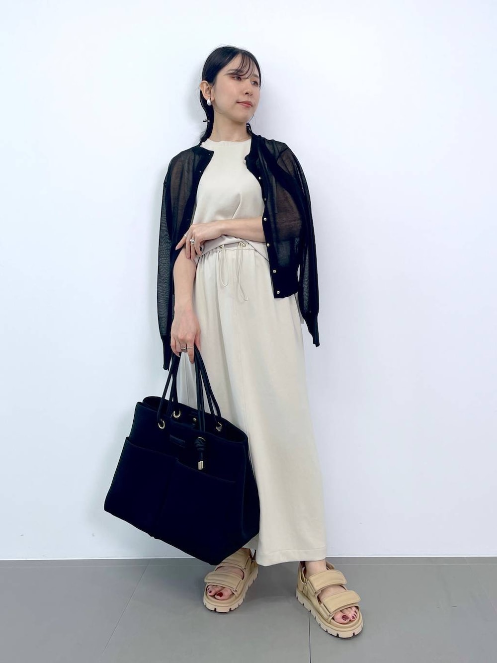ホワイト系のTシャツ/カットソー、ホワイト系のスカート、ブラック系のトートバッグを着用したレディースの夏コーディネートの1枚目の写真