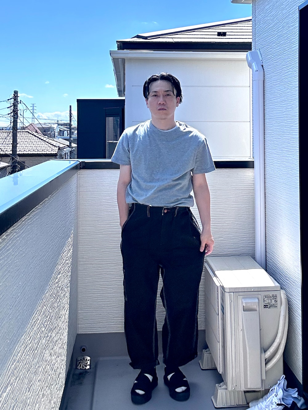 グレー系のTシャツ/カットソー、ブラック系のデニムパンツ、ブラック系のサンダルを着用したメンズの夏コーディネートの1枚目の写真