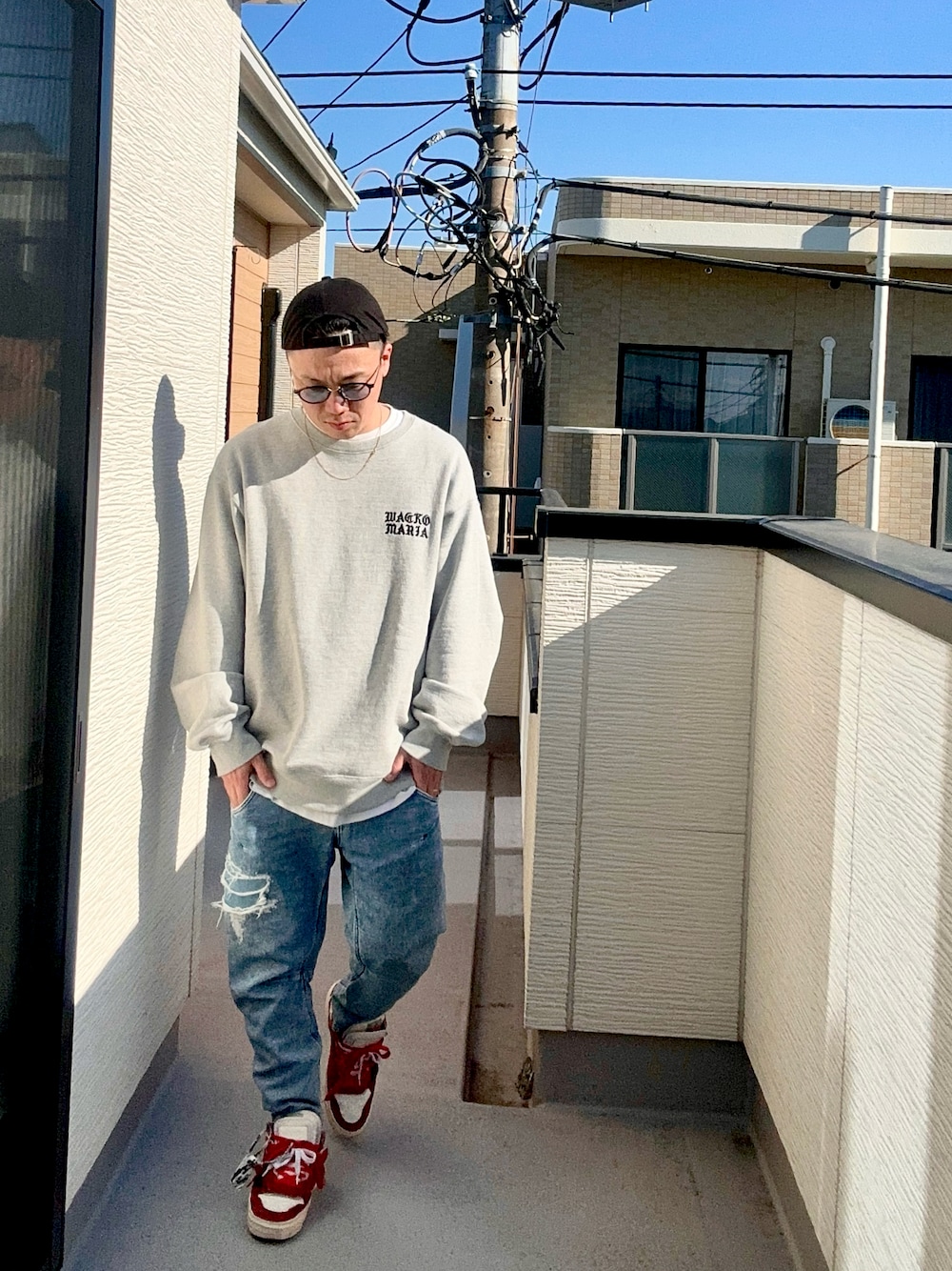 ブルー系のデニムパンツ、グレー系のスウェット、レッド系のシューズを着用したメンズの冬コーディネートの1枚目の写真