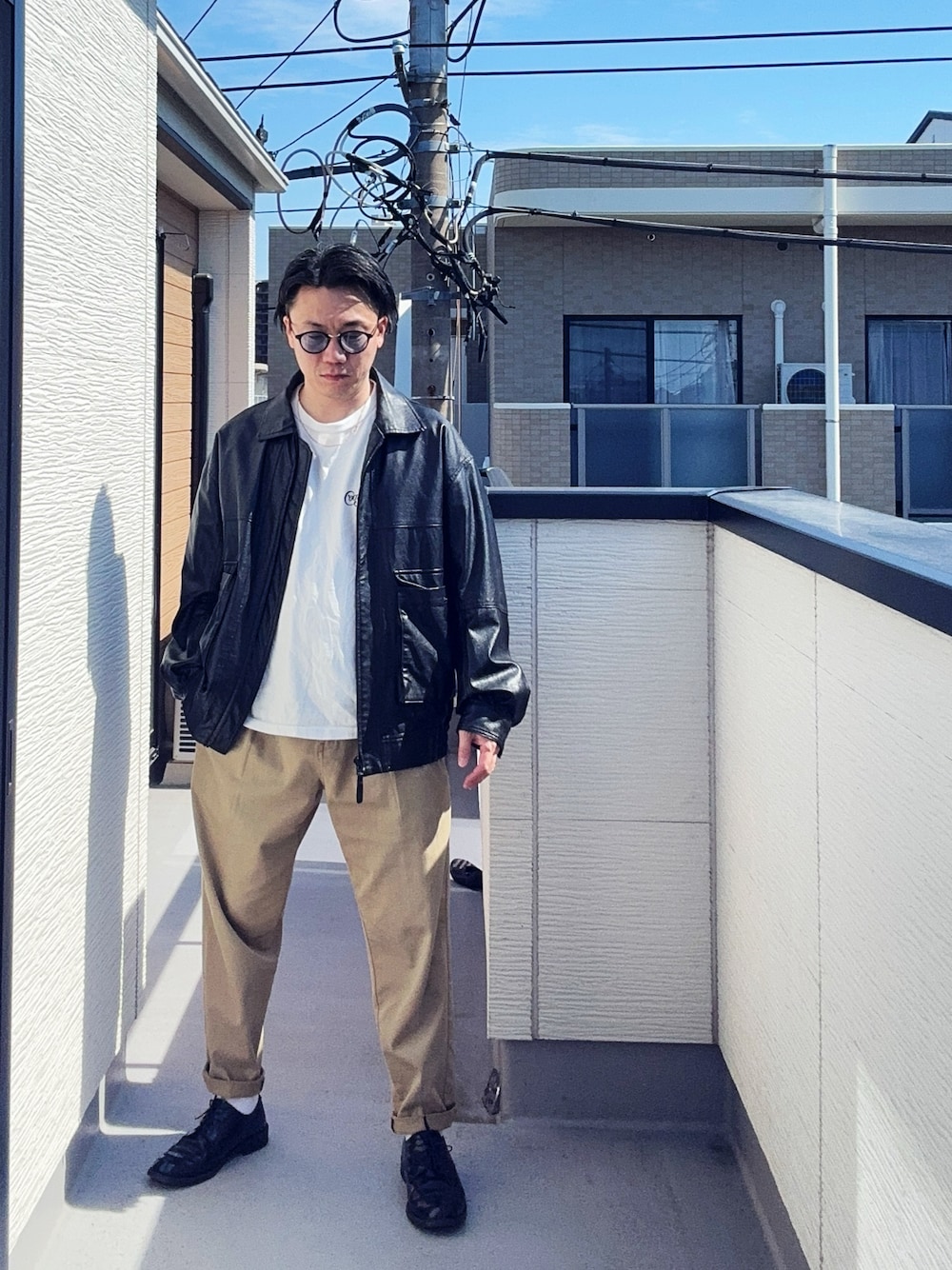ブラック系のブルゾン、グリーン系のチノパンツ、ホワイト系のTシャツ/カットソーを着用したメンズの春コーディネートの1枚目の写真
