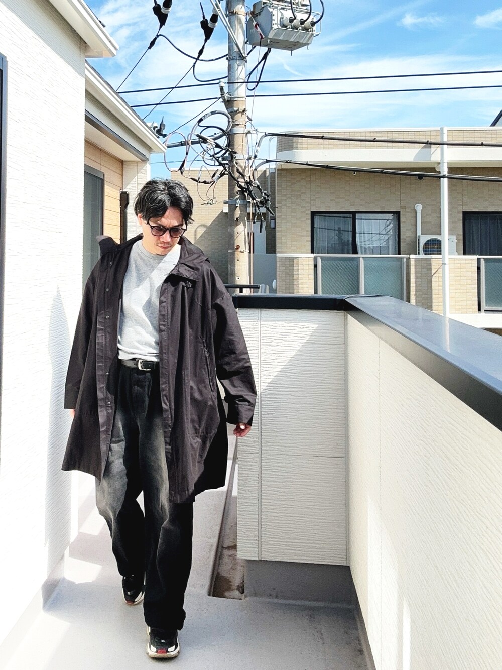 グレー系のTシャツ/カットソー、ブラック系のデニムパンツ、ブラック系のシューズを着用したメンズの秋コーディネートの1枚目の写真