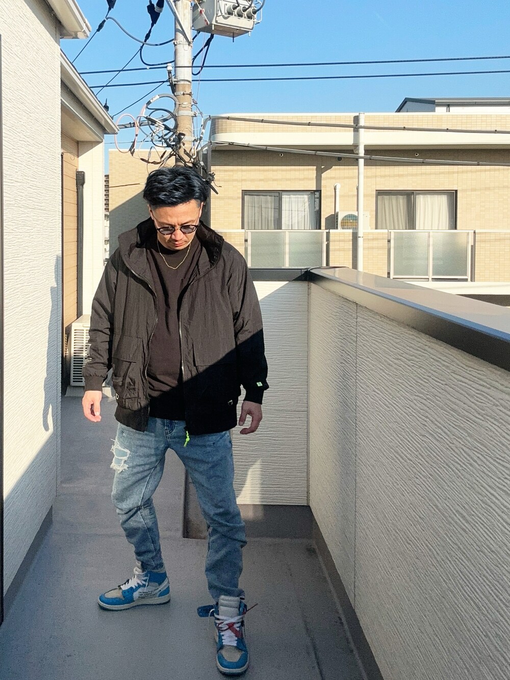 ブルー系のデニムパンツ、ブラック系のTシャツ/カットソー、ブラック系のブルゾンを着用したメンズの冬コーディネートの1枚目の写真