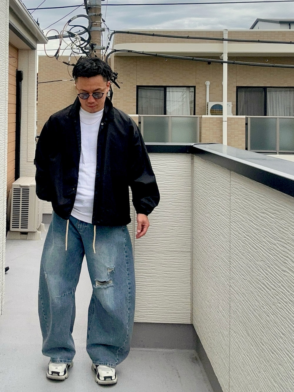 ブルー系のデニムパンツ、ブラック系のナイロンジャケット、ホワイト系のTシャツ/カットソーを着用したメンズの秋コーディネートの1枚目の写真