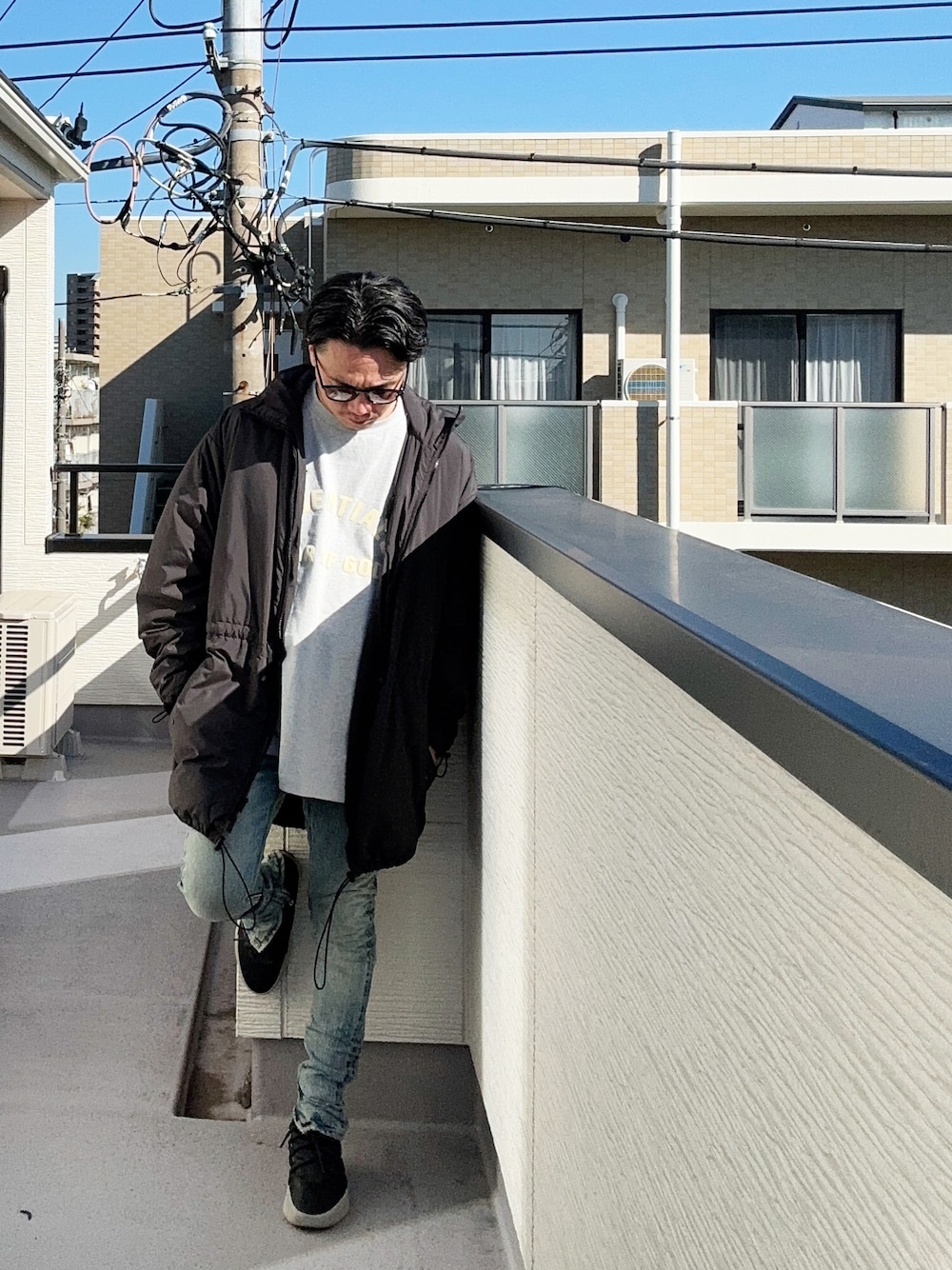 グレー系のTシャツ/カットソー、ブラック系のその他アウター、ブルー系のデニムパンツを着用したメンズの冬コーディネートの1枚目の写真