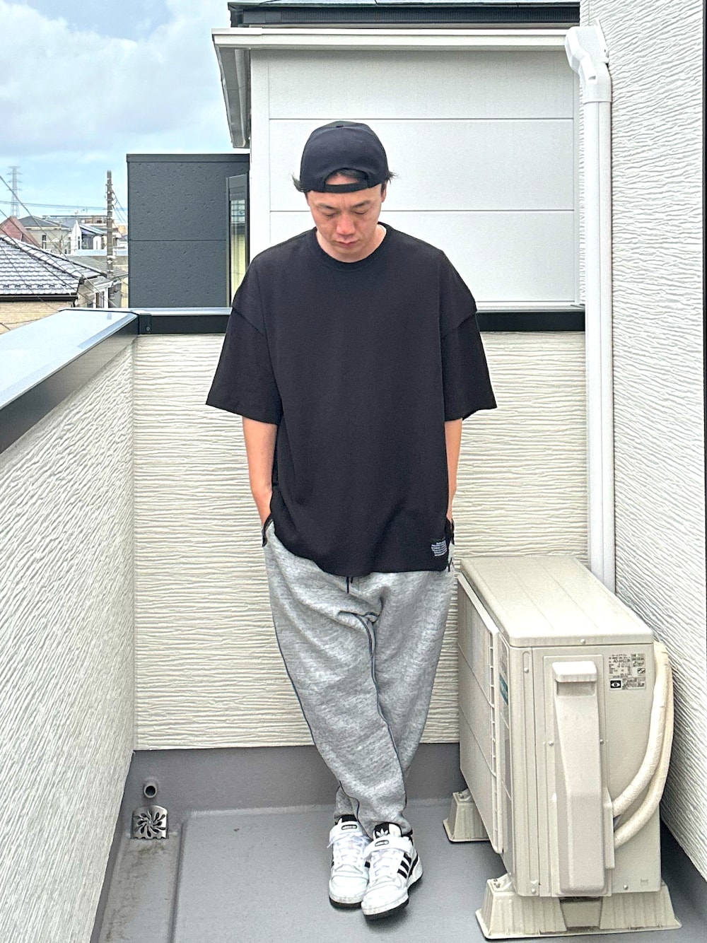 ブラック系のその他トップス、グレー系のパンツ、ホワイト系のスニーカーを着用したメンズの夏コーディネートの1枚目の写真