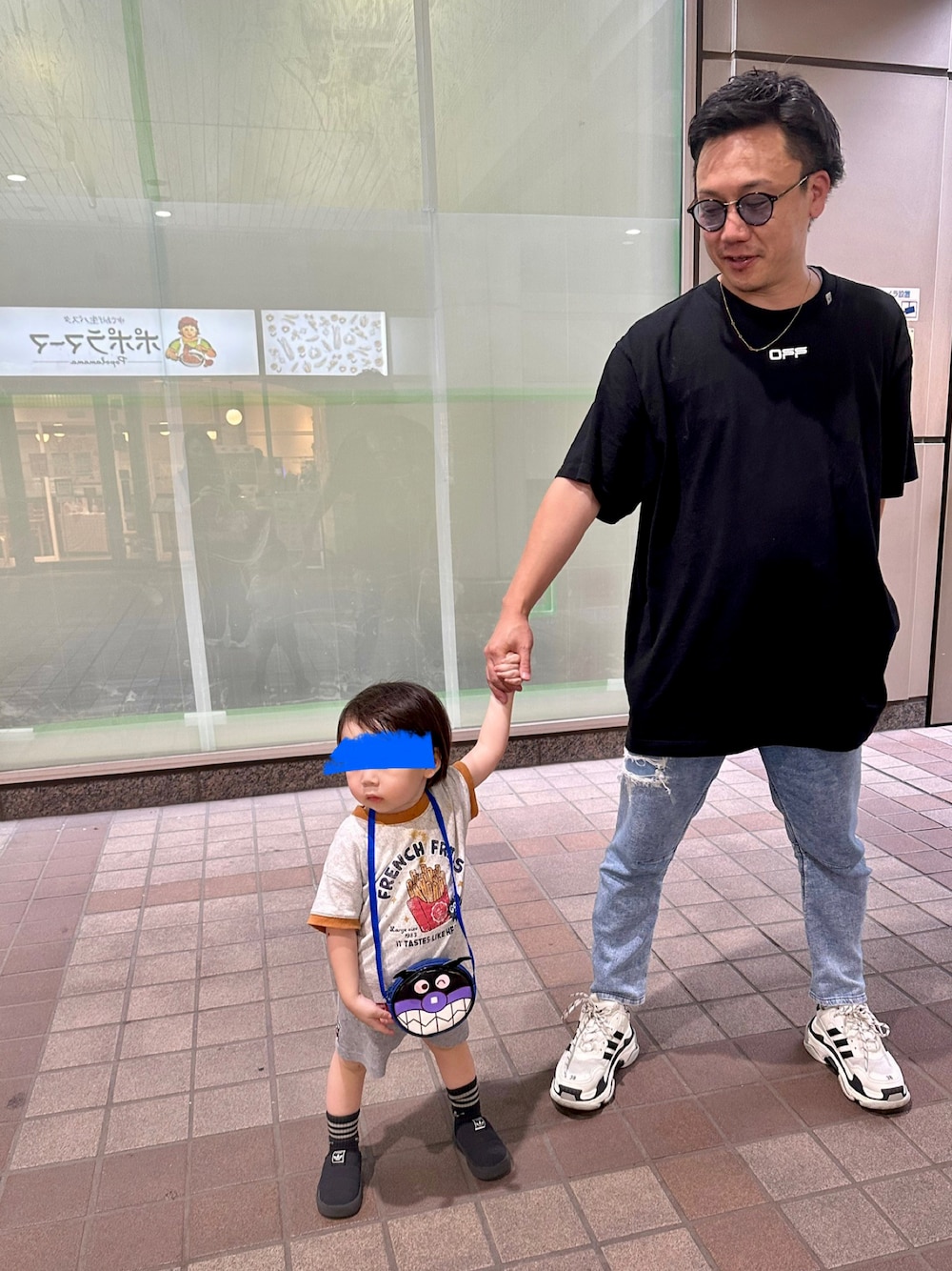 ブルー系のデニムパンツ、ブラック系のTシャツ/カットソー、ホワイト系のシューズを着用したメンズの秋コーディネートの1枚目の写真