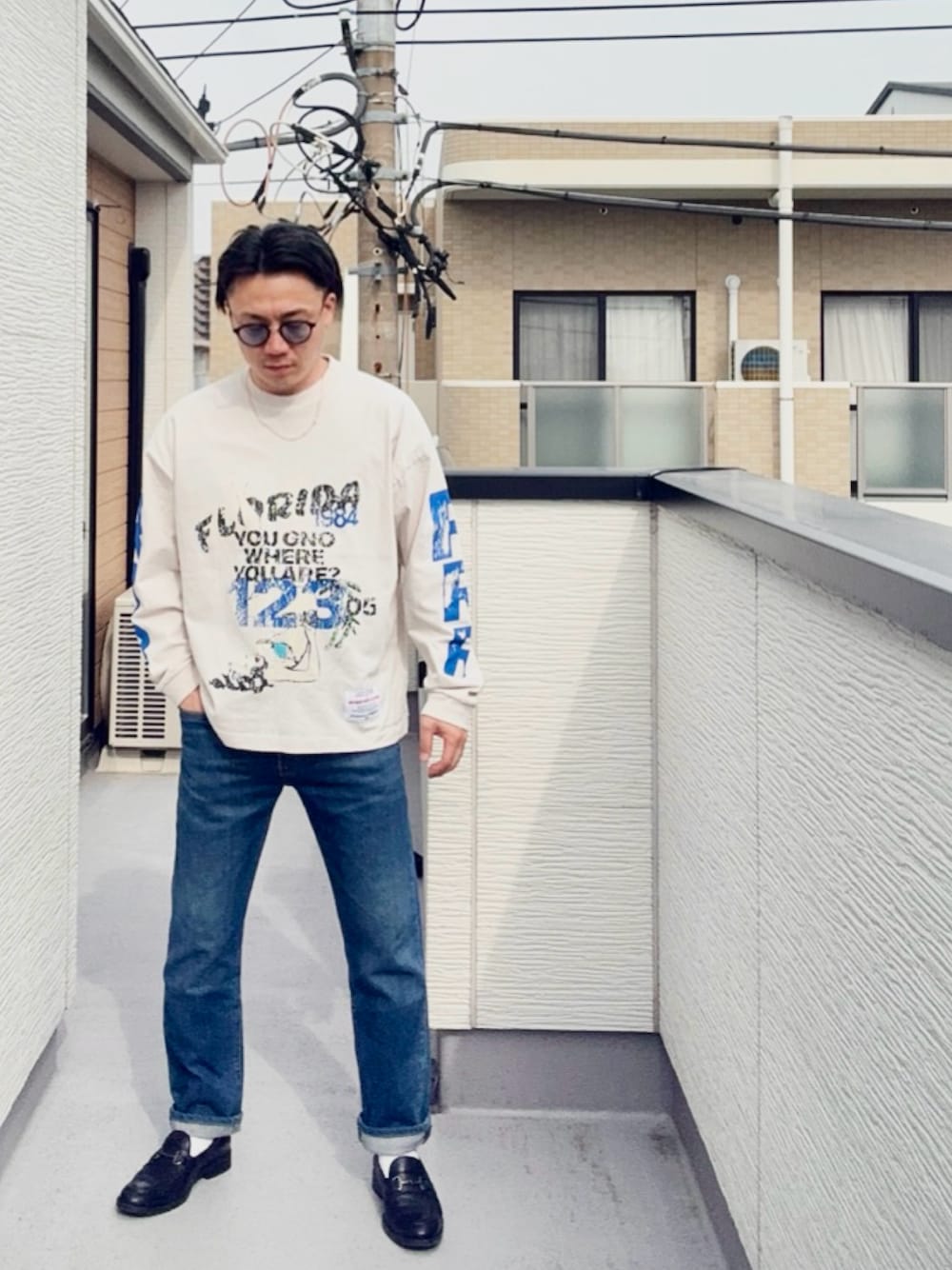 ブルー系のデニムパンツ、ブラック系のローファー、ホワイト系のTシャツ/カットソーを着用したメンズの春コーディネートの1枚目の写真