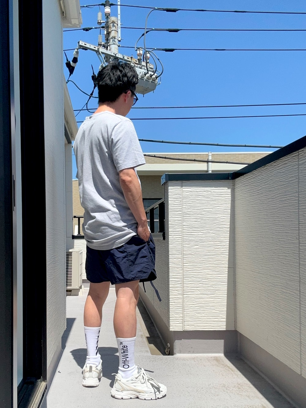 グレー系のTシャツ/カットソー、ブルー系のパンツ、ホワイト系のスニーカーを着用したメンズの夏コーディネートの1枚目の写真