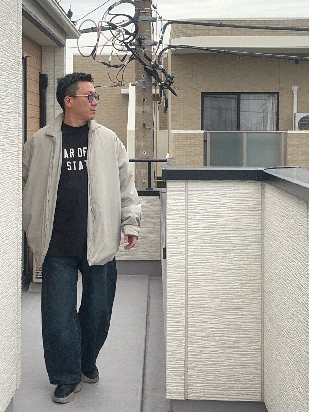 ブラック系のTシャツ/カットソー、ブラック系のその他アウター、ブルー系のデニムパンツを着用したメンズの秋コーディネートの1枚目の写真