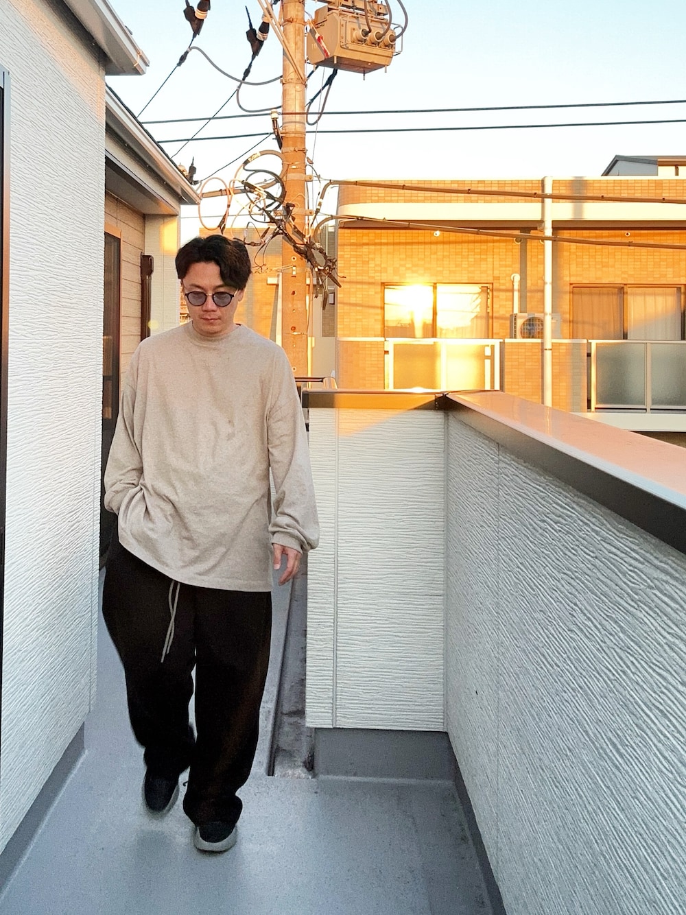 グレー系のTシャツ/カットソー、ブラック系のスウェットパンツ、ブラック系のスニーカーを着用したメンズの秋コーディネートの1枚目の写真