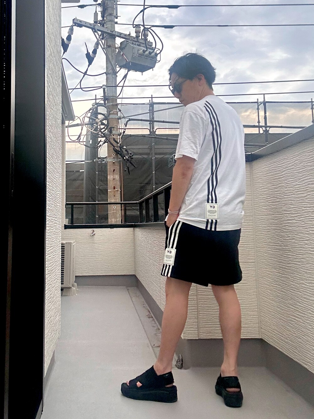 ホワイト系のTシャツ/カットソー、ブラック系のその他パンツ、ブラック系のサンダルを着用したメンズの夏コーディネートの1枚目の写真