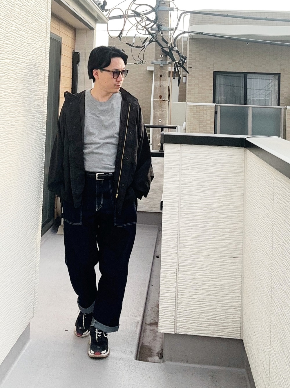 グレー系のTシャツ/カットソー、ブラック系のブルゾン、ブルー系のデニムパンツを着用したメンズの秋コーディネートの1枚目の写真