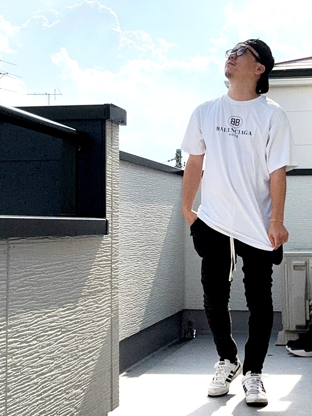 ホワイト系のTシャツ/カットソー、ブラック系のパンツ、ホワイト系のスニーカーを着用したメンズの秋コーディネートの1枚目の写真