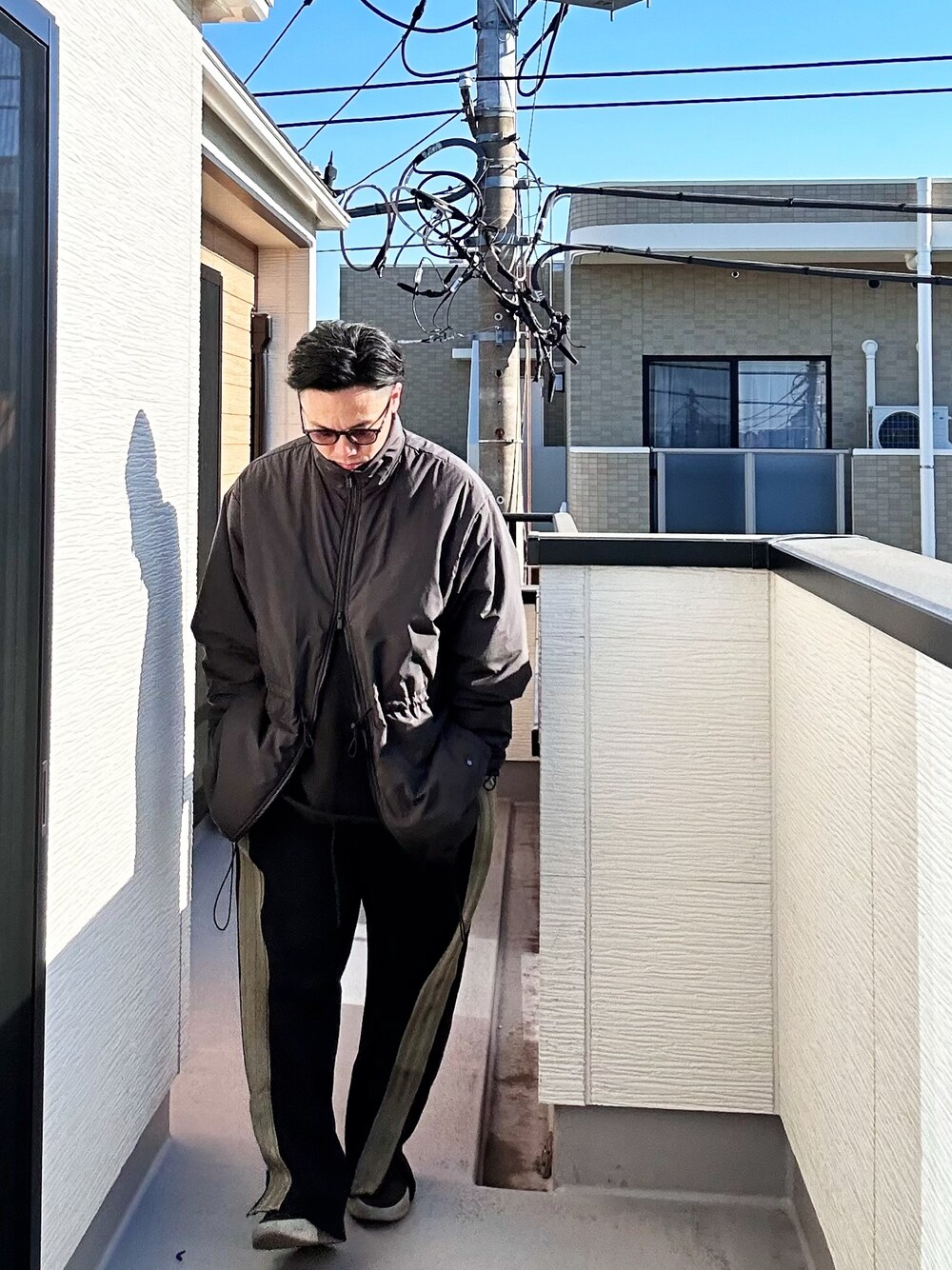 ブラック系のその他アウター、ブラック系のスウェット、ブラック系のパンツを着用したメンズの冬コーディネートの1枚目の写真