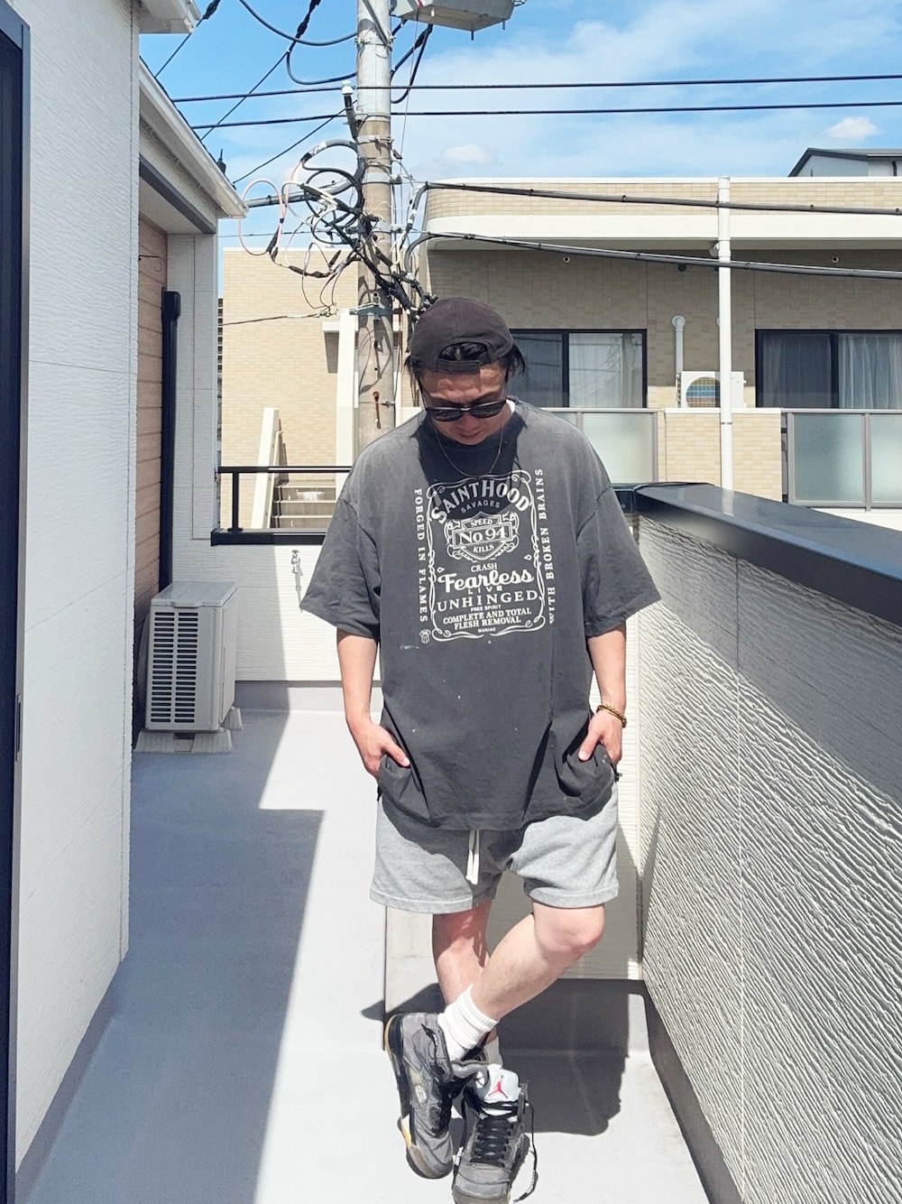 ブラック系のTシャツ/カットソー、グレー系のパンツ、グレー系のスニーカーを着用したメンズの夏コーディネートの1枚目の写真
