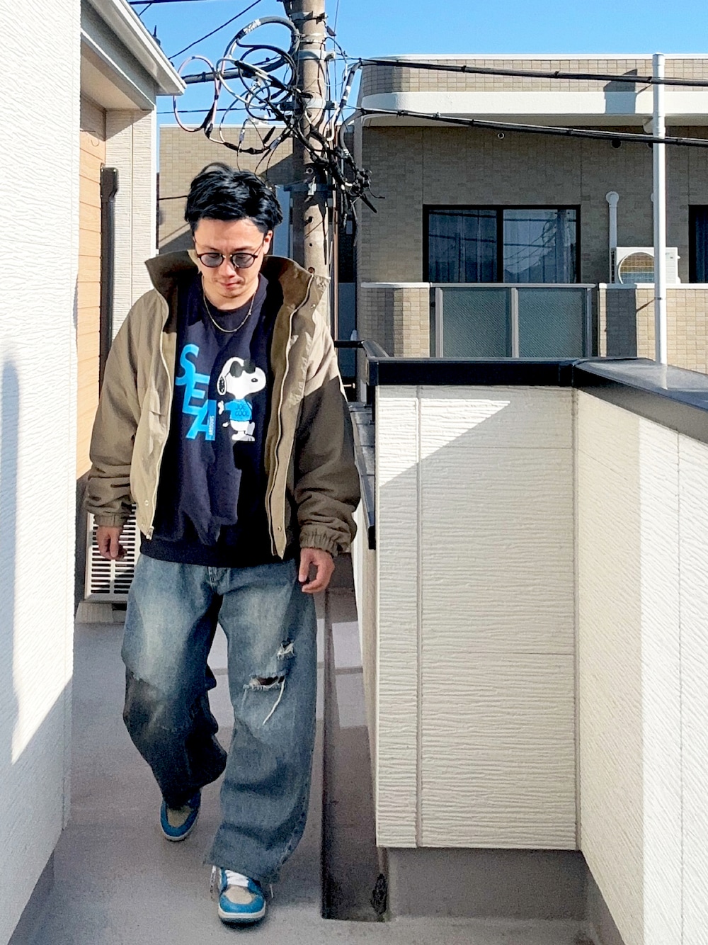 ブルー系のデニムパンツ、ベージュ系のブルゾン、ブルー系のスウェットを着用したメンズの冬コーディネートの1枚目の写真