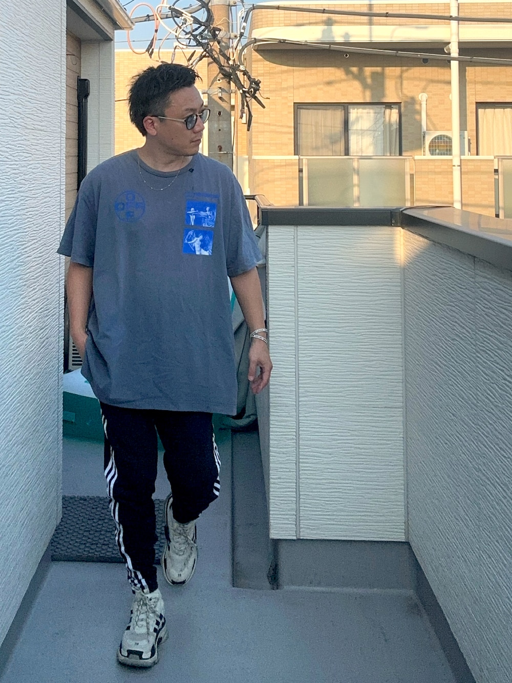 ブラック系のスウェットパンツ、ブルー系のTシャツ/カットソー、ホワイト系のシューズを着用したメンズの夏コーディネートの1枚目の写真