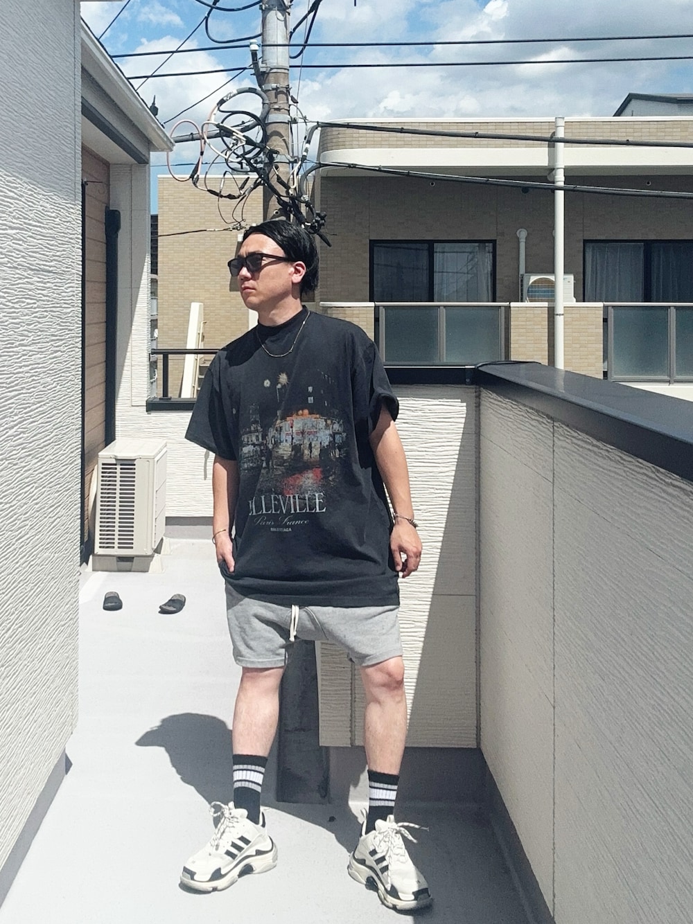 ブラック系のTシャツ/カットソー、グレー系のパンツ、ホワイト系のシューズを着用したメンズの夏コーディネートの1枚目の写真