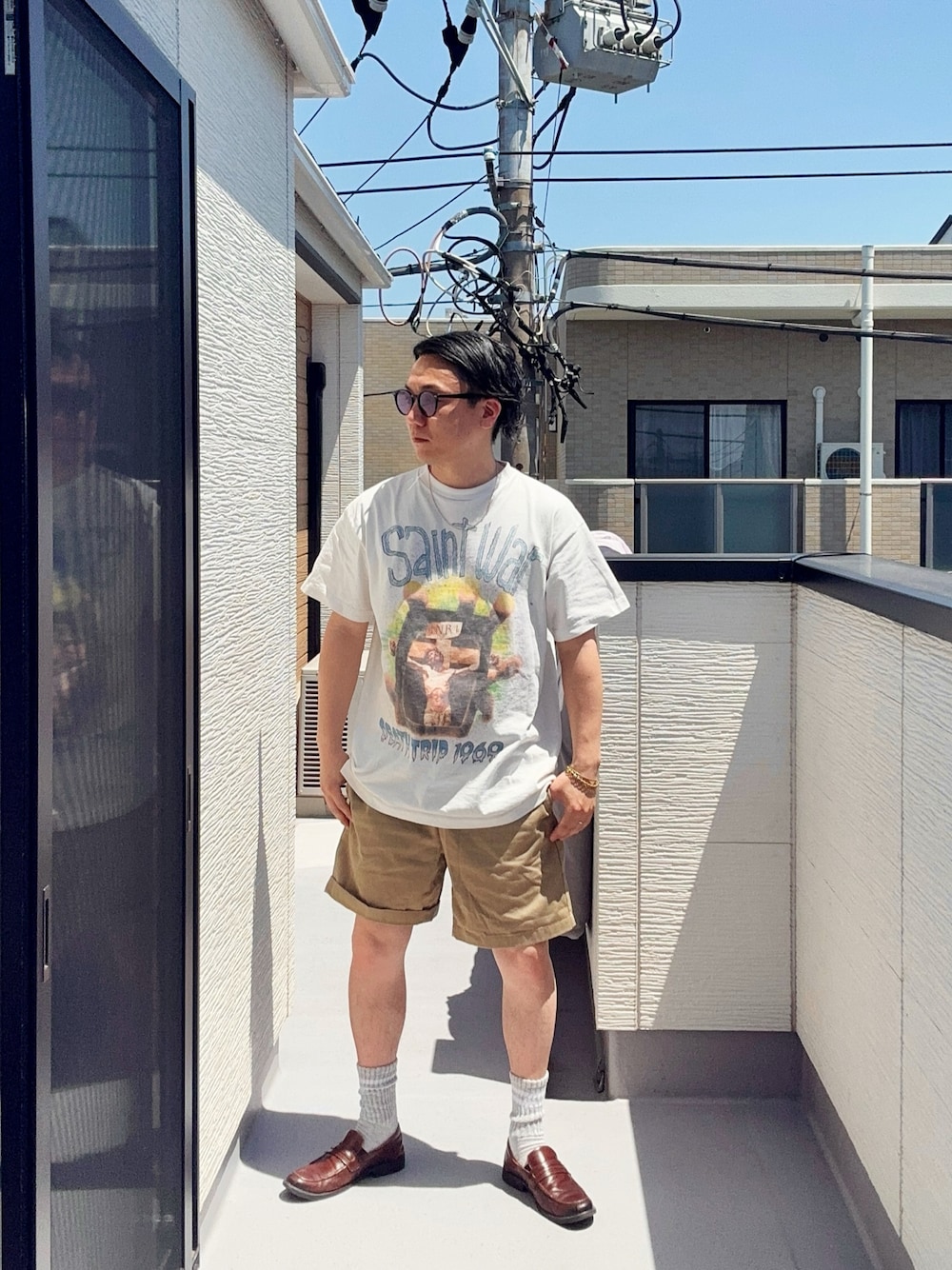 ホワイト系のTシャツ/カットソー、ベージュ系のパンツ、ブラウン系のローファーを着用したメンズの春コーディネートの1枚目の写真