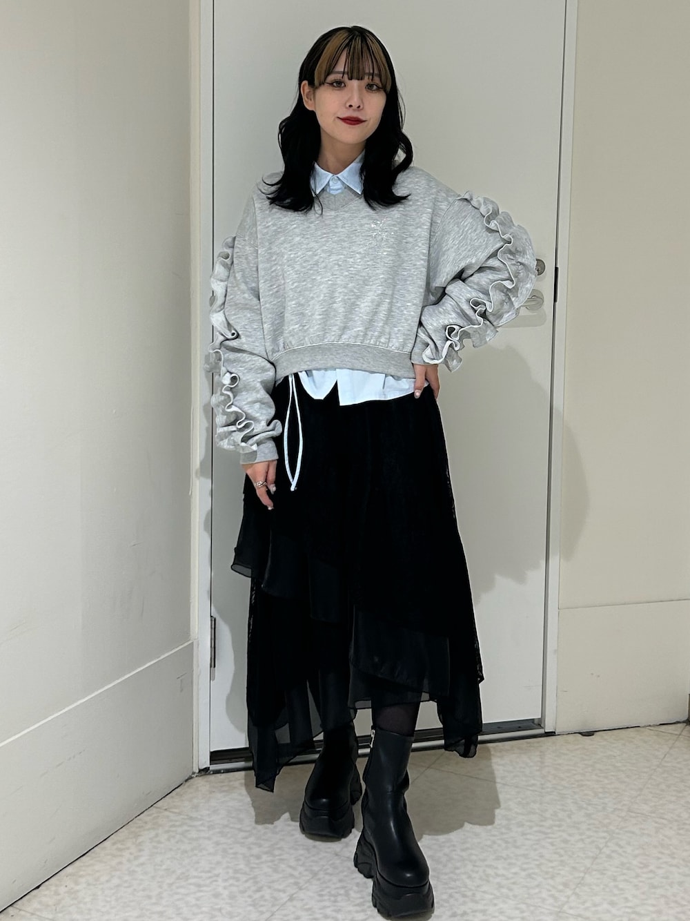 ブラック系のスカート、グレー系のスウェット、ブルー系のシャツ/ブラウスを着用したレディースの冬コーディネートの1枚目の写真