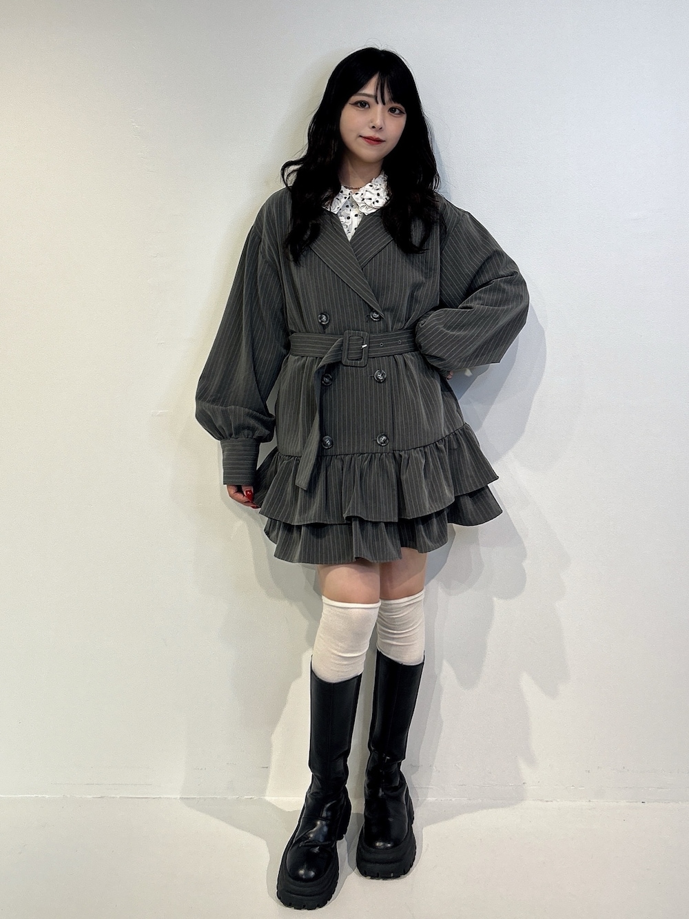 グレー系のワンピース、ブラック系のブーツを着用したレディースの秋コーディネートの1枚目の写真