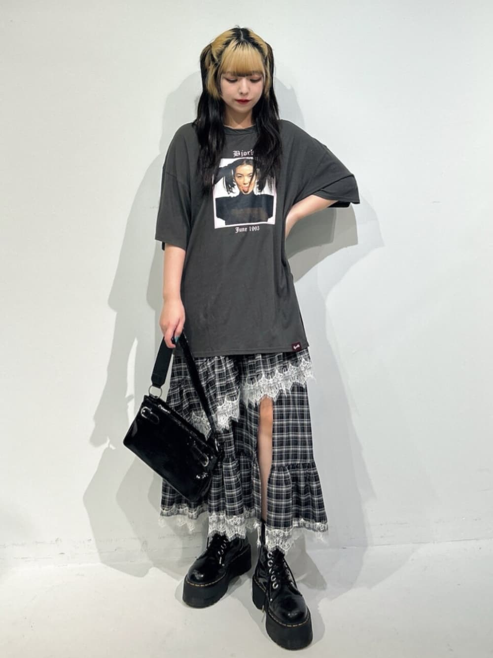 ブラック系のハンドバッグ、ブラック系のブーツ、グレー系のワンピースを着用したレディースの冬コーディネートの1枚目の写真