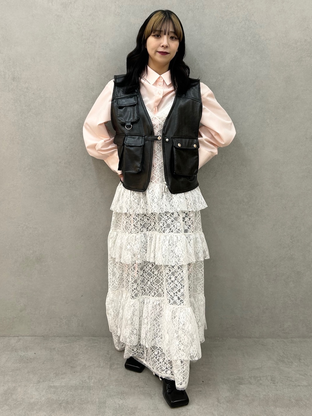 ブラック系のパンプス、ホワイト系のワンピース、ブラック系のベストを着用したレディースの冬コーディネートの1枚目の写真