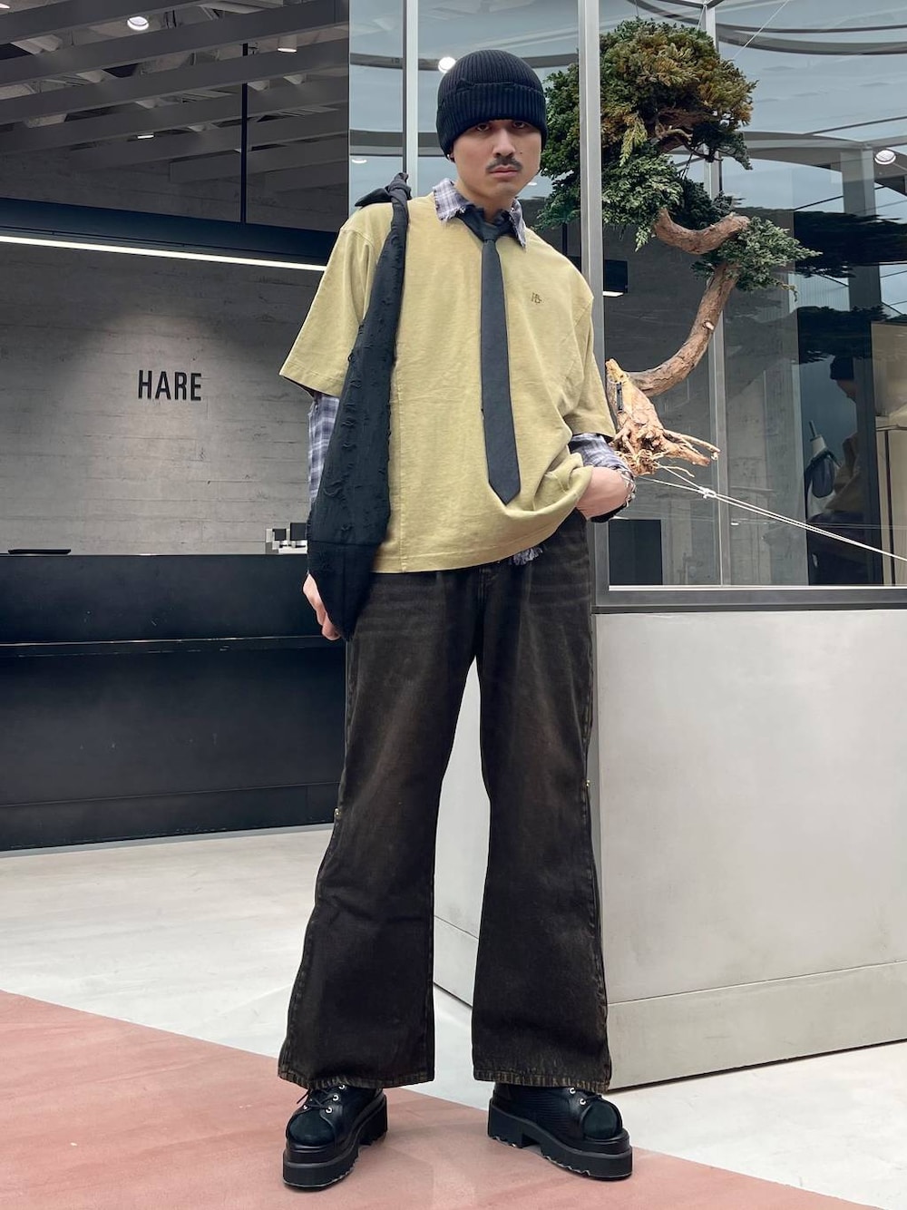 グレー系のシャツ/ブラウス、イエロー系のTシャツ/カットソー、オレンジ系のデニムパンツを着用したメンズの春コーディネートの1枚目の写真