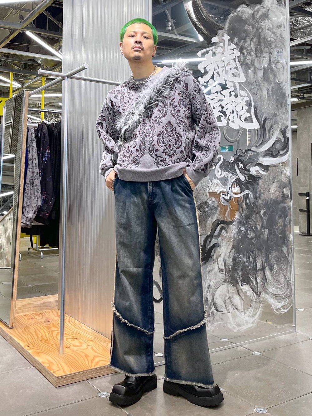 ブルー系のデニムパンツ、グレー系のニット/セーター、グレー系のショルダーバッグを着用したメンズの秋コーディネートの1枚目の写真