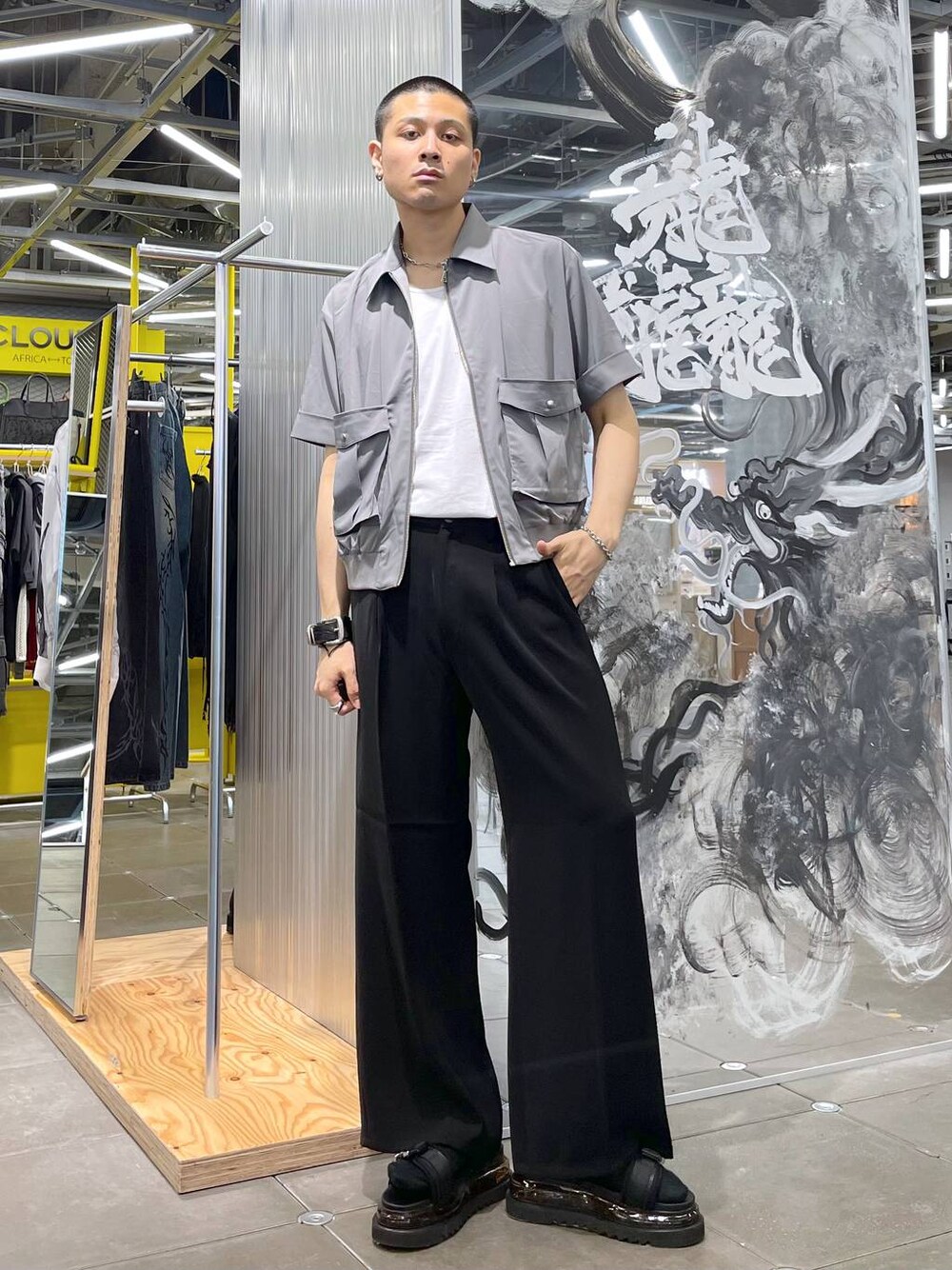 ブラック系のスラックス、グレー系のシャツ/ブラウス、ブラック系のサンダルを着用したメンズの夏コーディネートの1枚目の写真