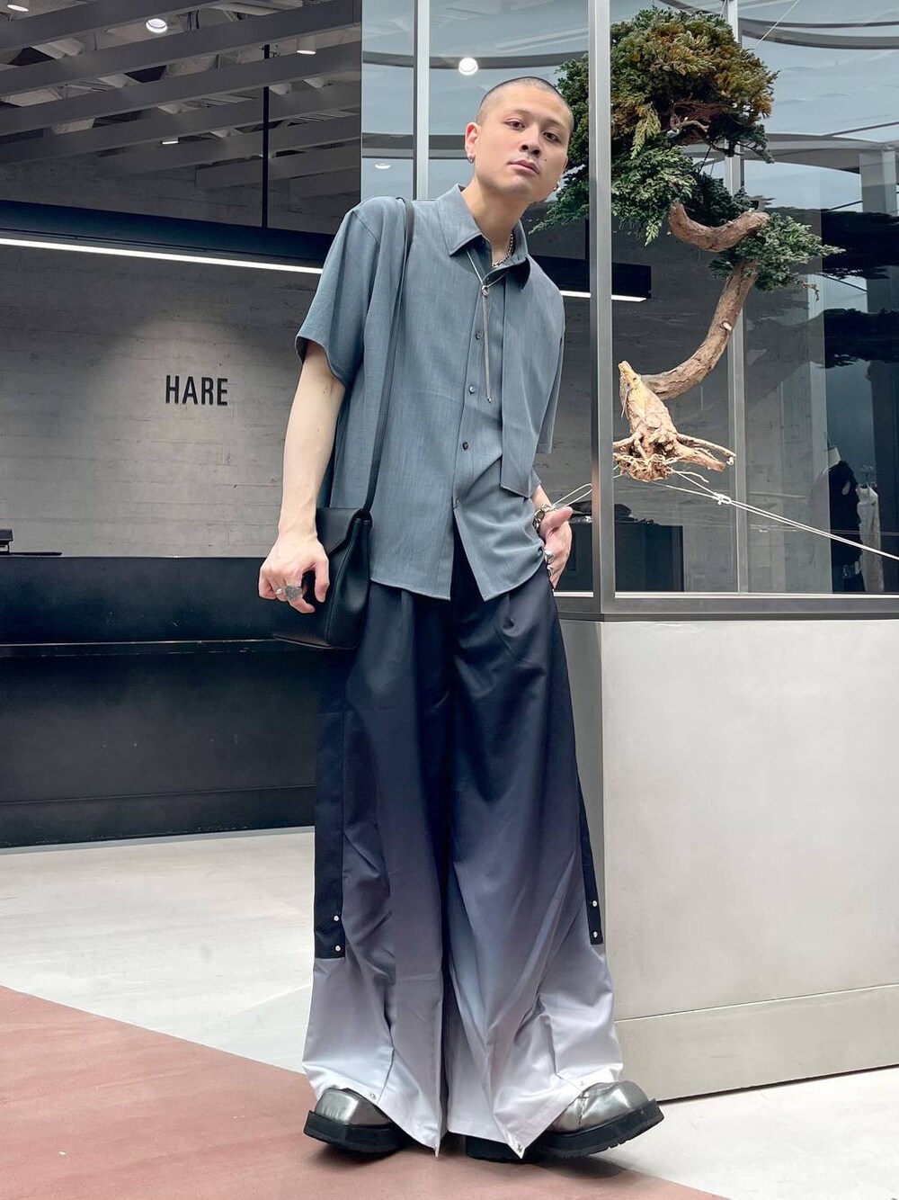 ブラック系のその他パンツ、ブルー系のシャツ/ブラウス、ブラック系のショルダーバッグを着用したメンズの春コーディネートの1枚目の写真