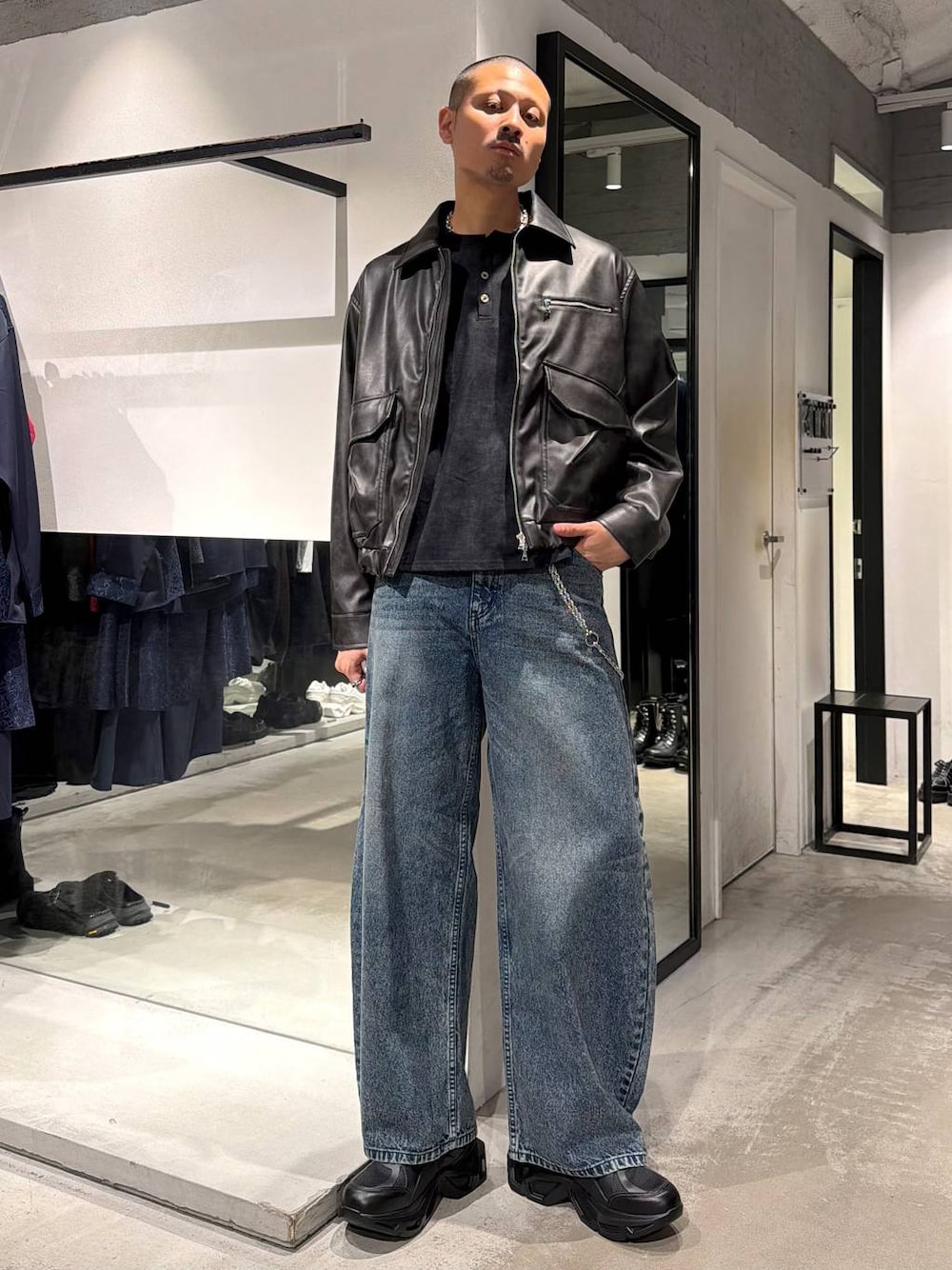 ブルー系のデニムパンツ、ブラック系のTシャツ/カットソー、ブラック系のスニーカーを着用したメンズの秋コーディネートの1枚目の写真