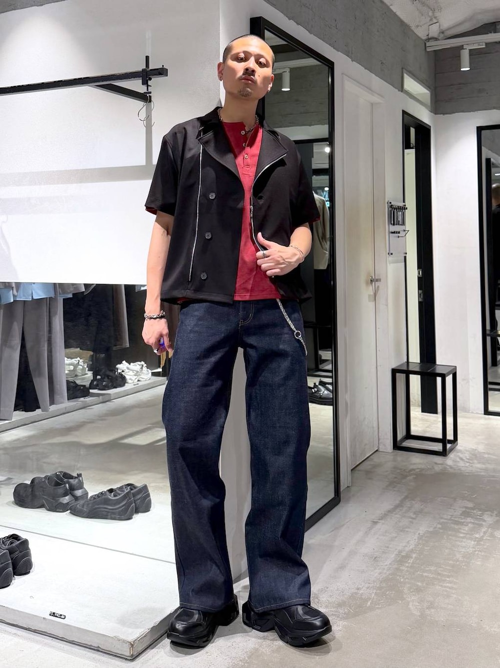 ブラック系のスニーカー、レッド系のTシャツ/カットソー、ブルー系のデニムパンツを着用したメンズの夏コーディネートの1枚目の写真